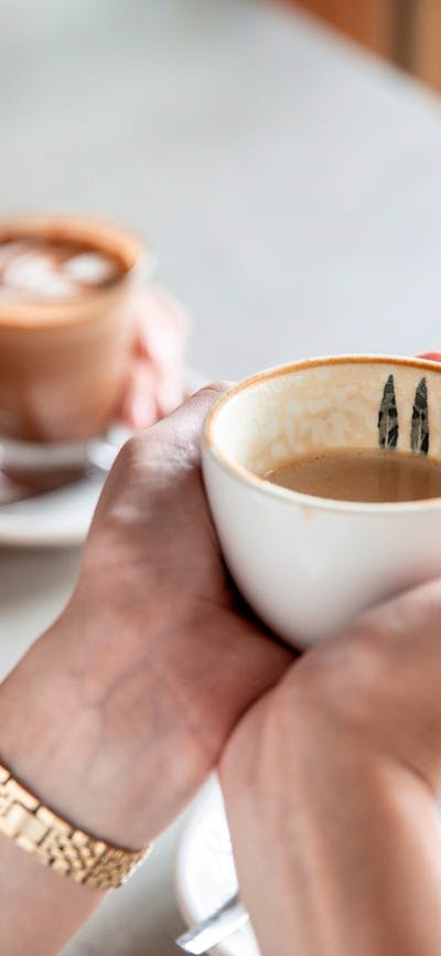 Person holding coffee cup with two hands