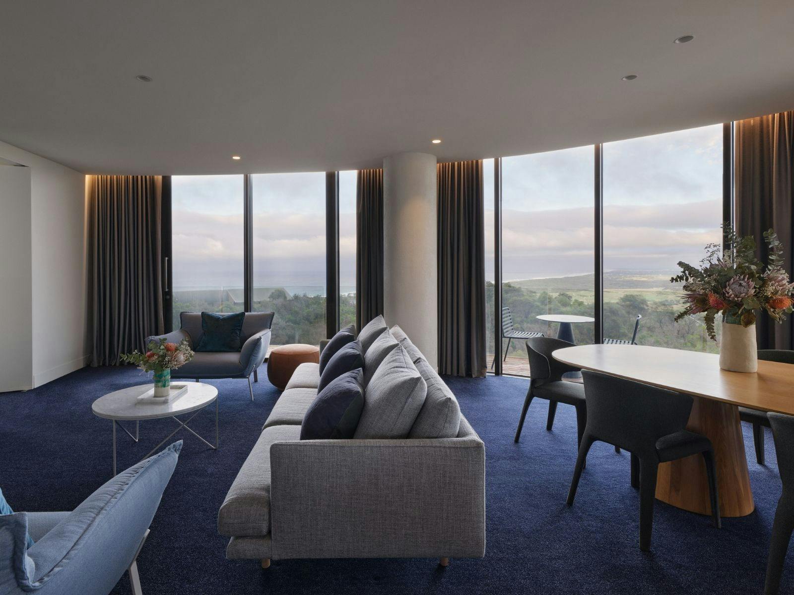 Living room with large couch and views across the ocean and landscape