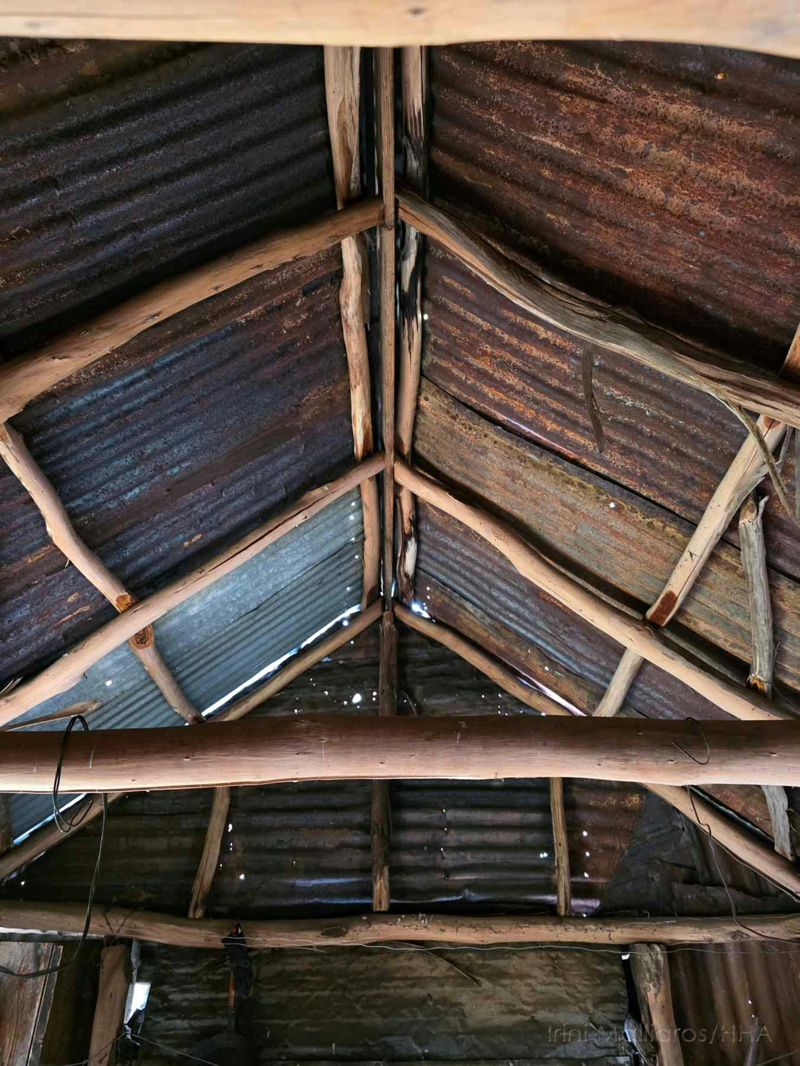 Interior view of the roof of a mountain hut shwing iron sheeting and timber supports.