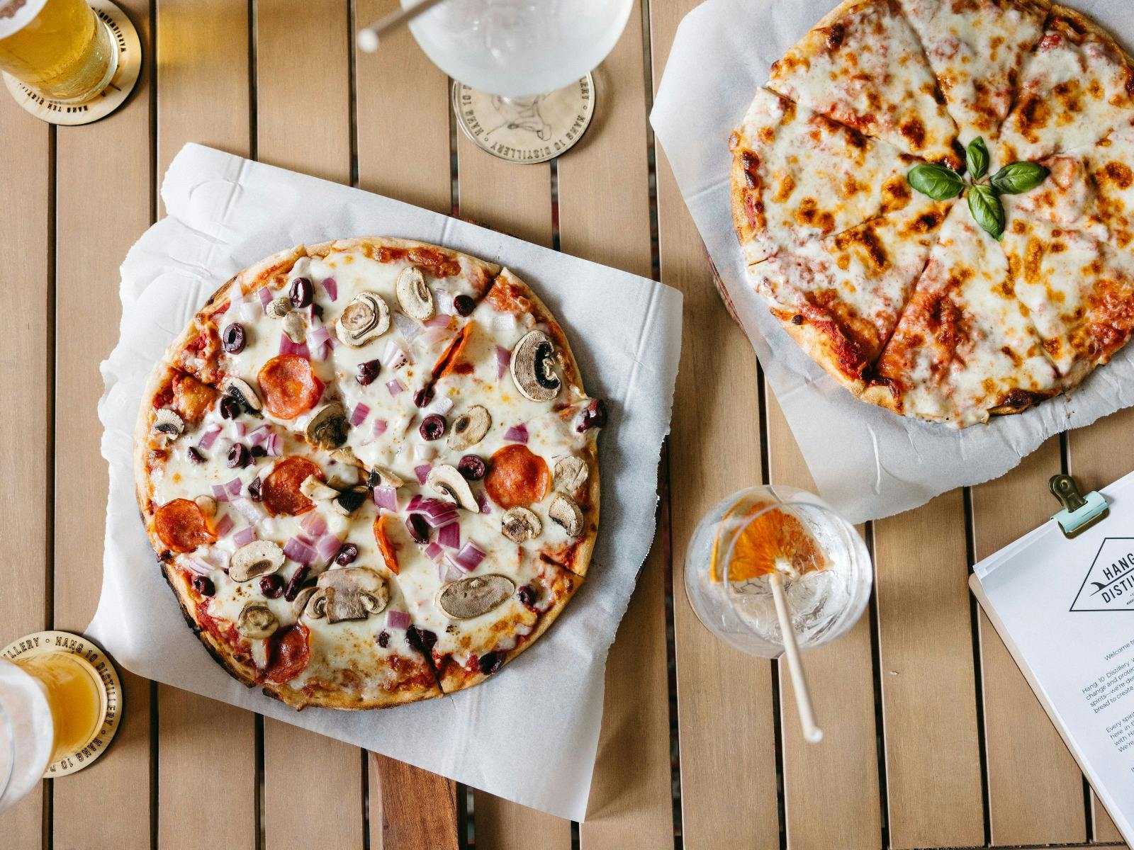 Two pizzas with beer and drinks at Hang 10 Distillery