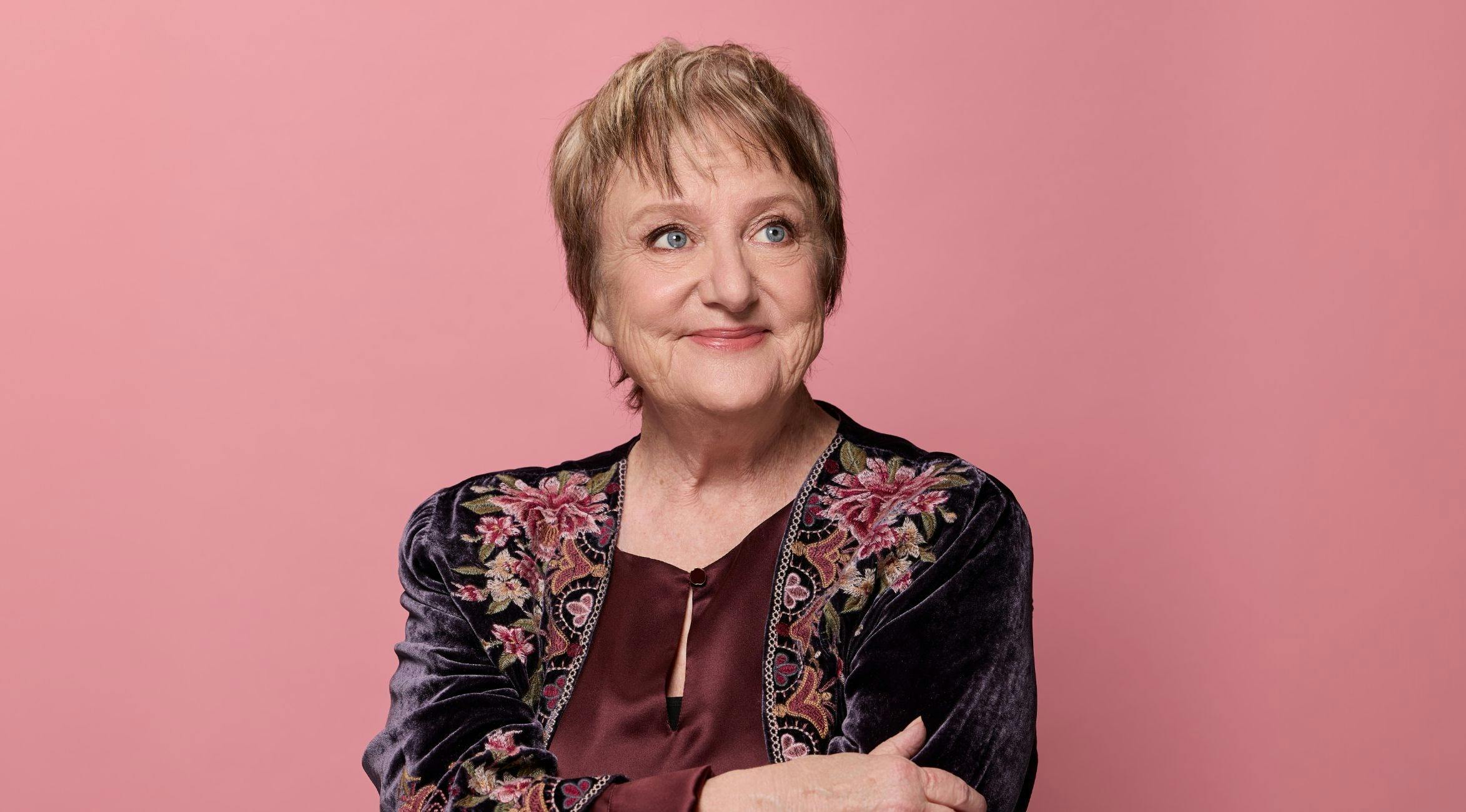 Denise Scott infront of a pink background