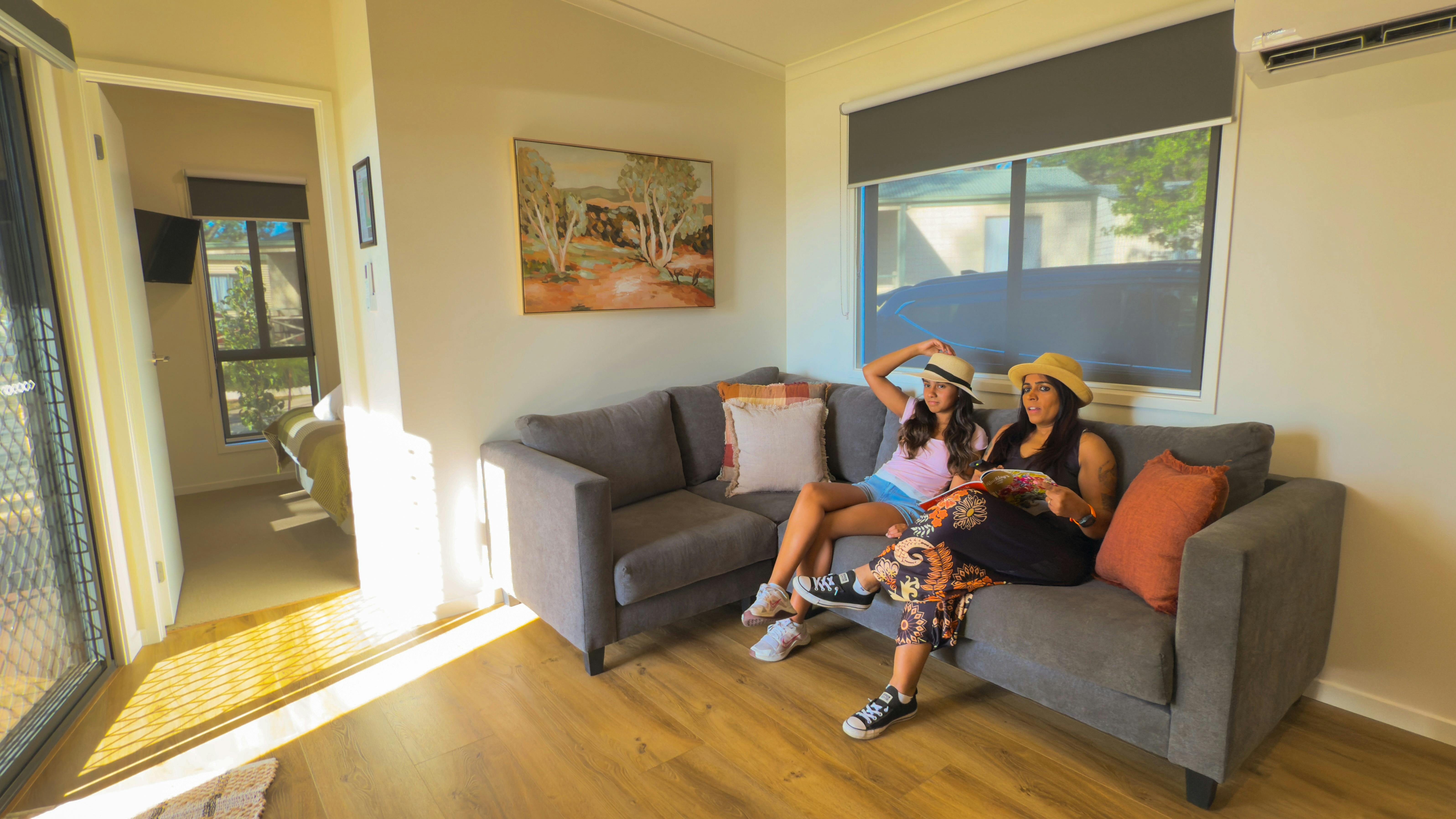 Guests watching TV in BIG4 Rutherglen Holiday Parks Deluxe Lakeview Cabin