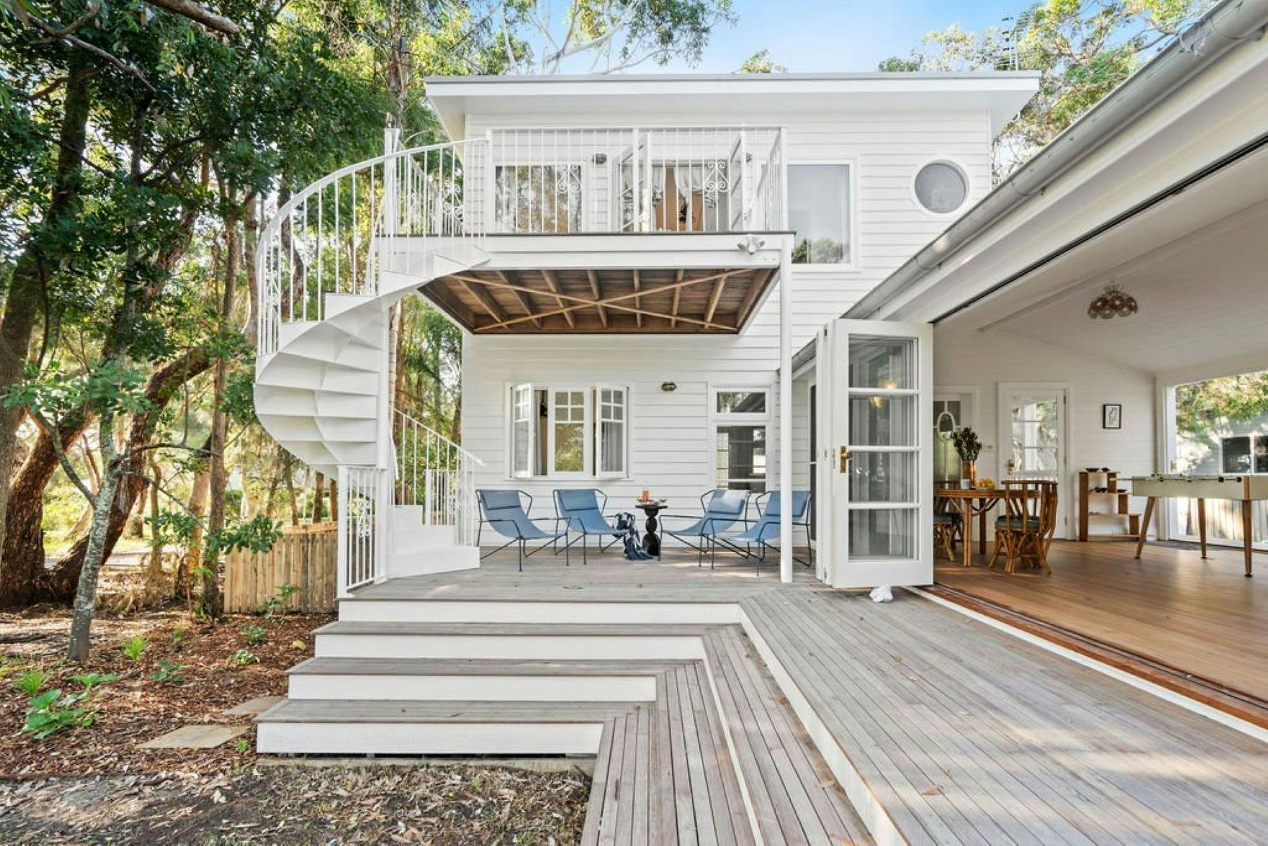 Image of front facade. Spiral staircase is featured as the focal point. Bushland surrounds property.