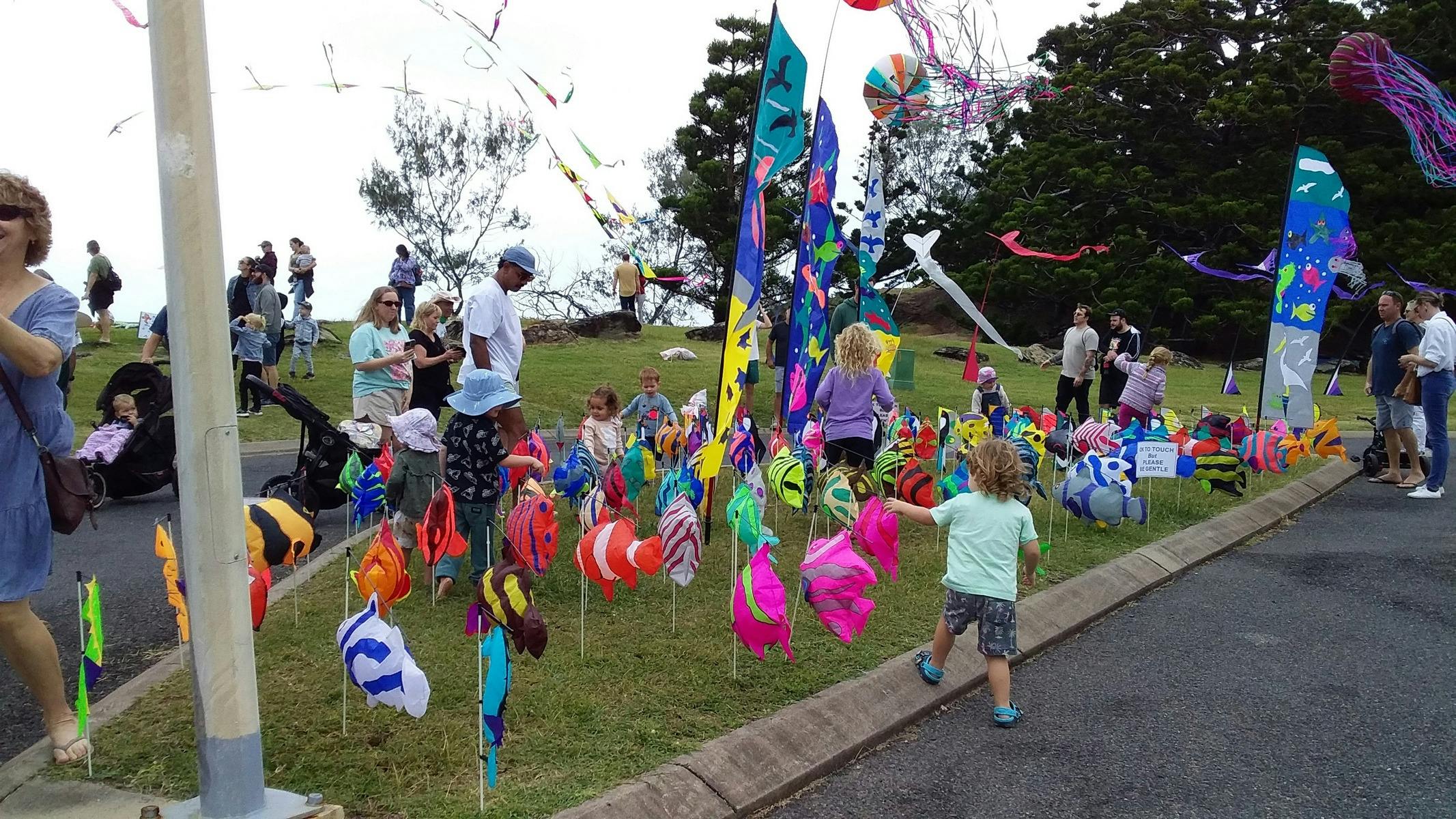 Kiddies playing amongst ground kites