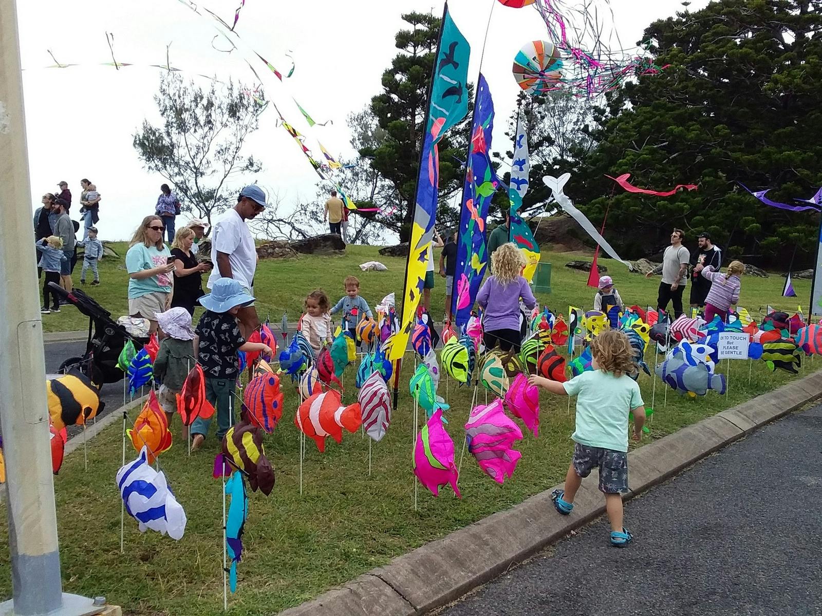 Kiddies playing amongst ground kites