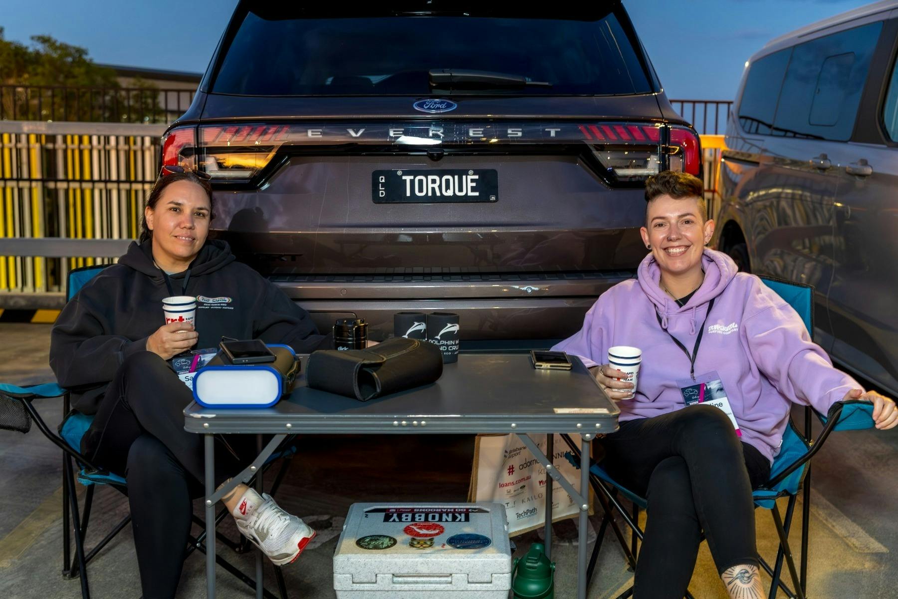 Two Gold Coast Live Like Her Challenge participants sitting in camp chairs with coffee