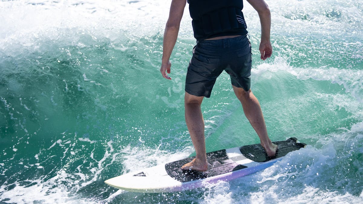 Close up of a crystal clear blue water peeling wave with a wake surfer living his best life