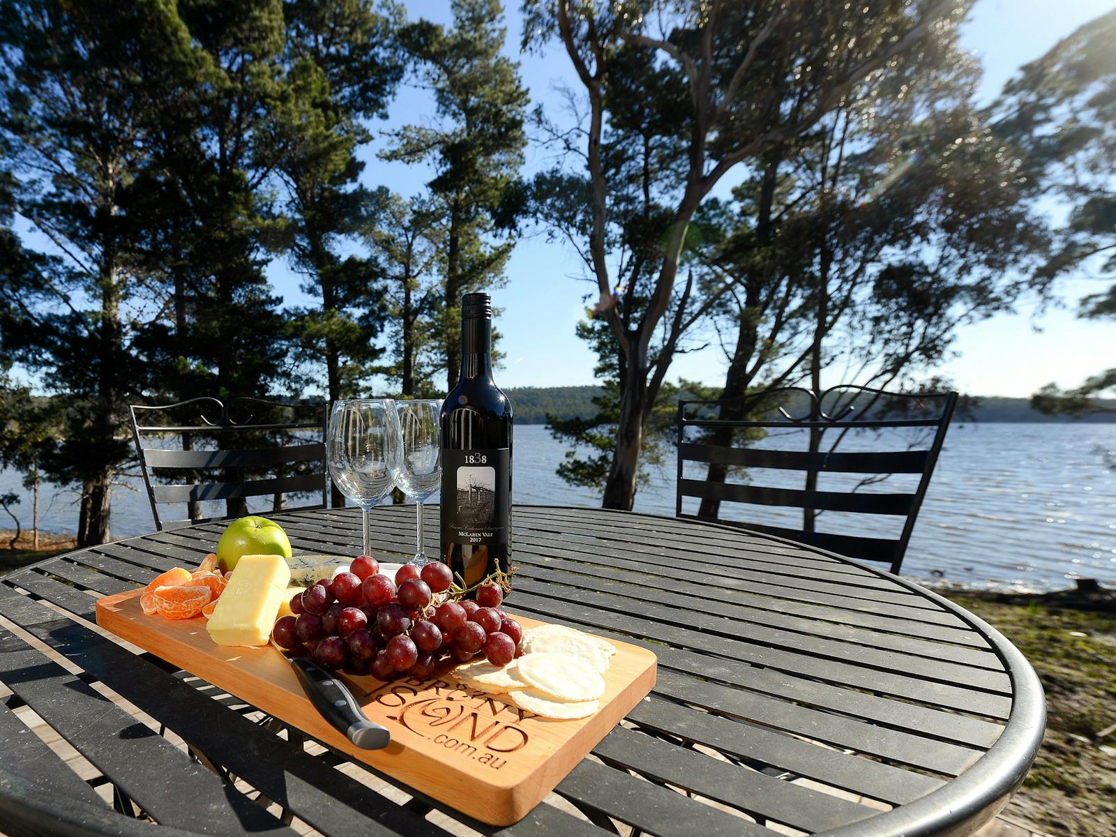 Taylors Bay Cottage:  wine and cheese platter upon table on the deck.