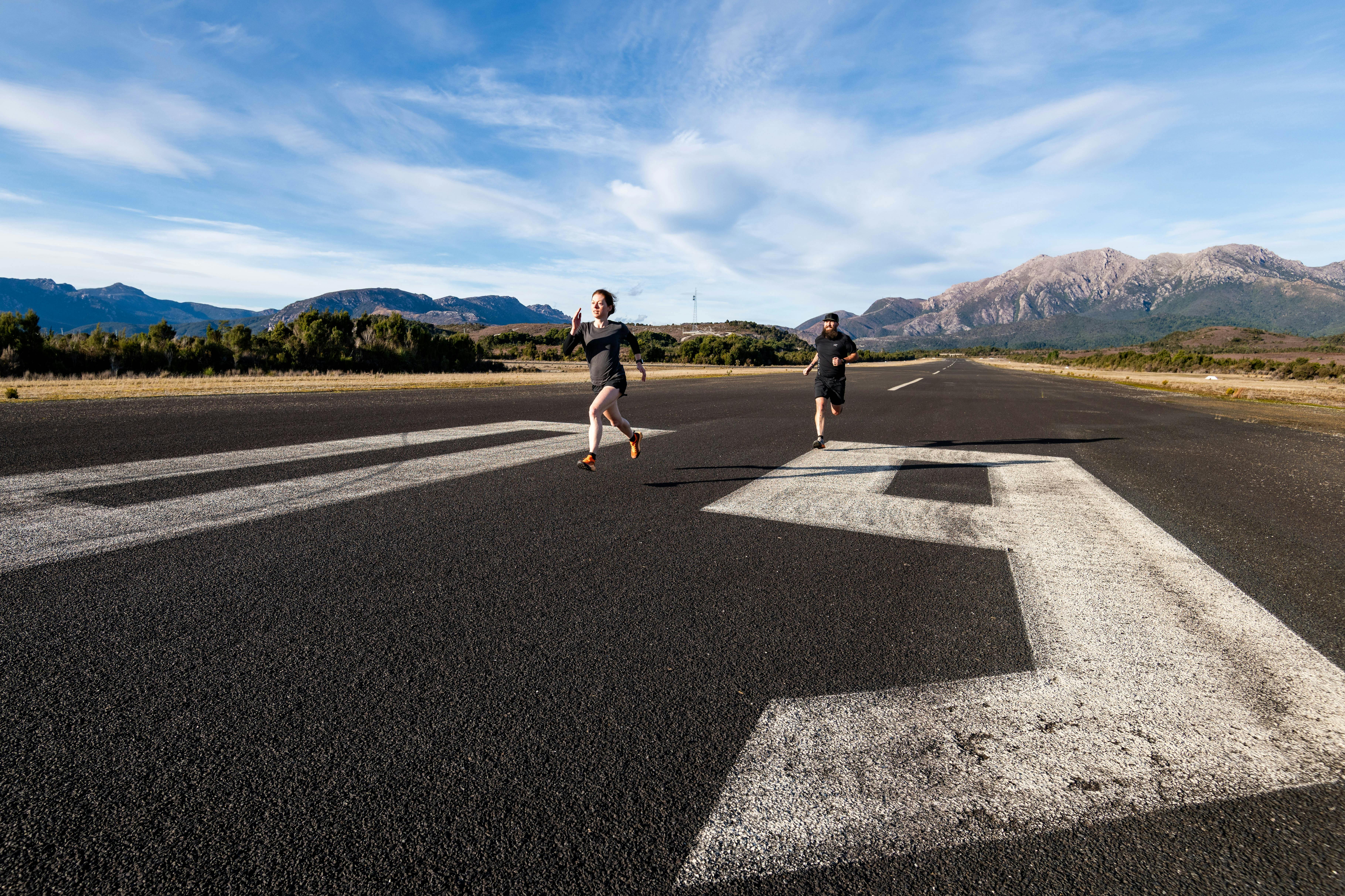 A male and female runner on the tarmac of Queenstown Airfield