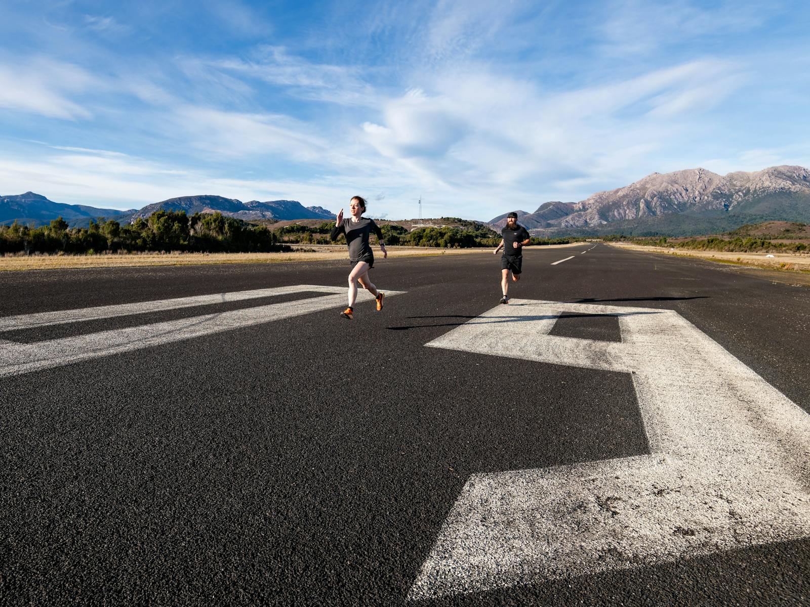 A male and female runner on the tarmac of Queenstown Airfield