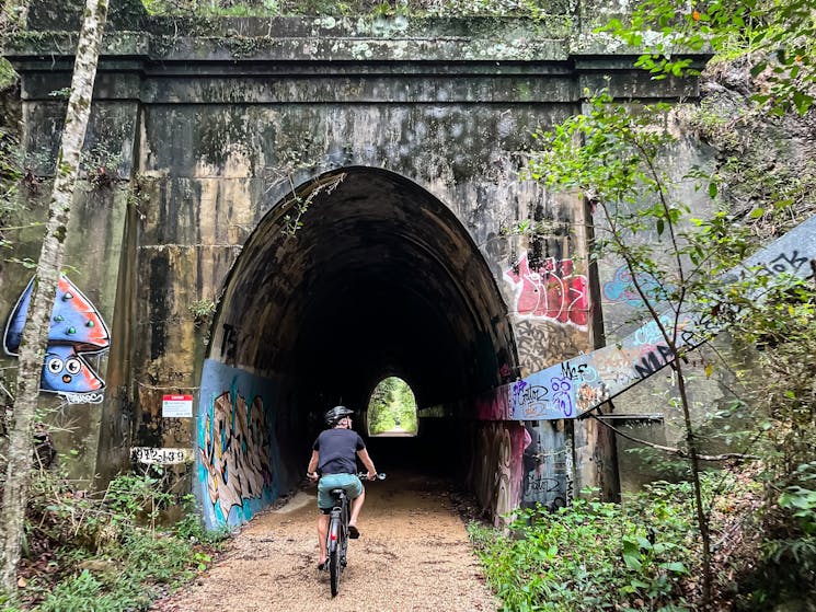 Cyclist entering a tunnel on the Northern Rivers Rail Trail E Bike self guided tour