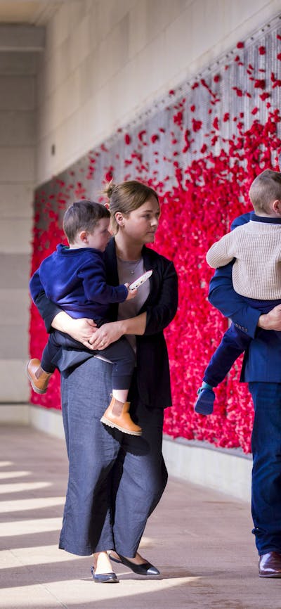Family visiting the Australian War Memorial and walking through the Roll of Honour
