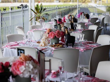 Round Table settings decorated with pink menus and florals