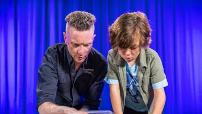 A man and a boy explore patterns using coloured blocks