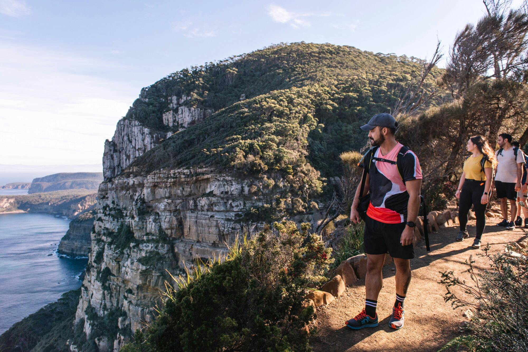 walkers on the Cape Raoul track with sea cliffs in background