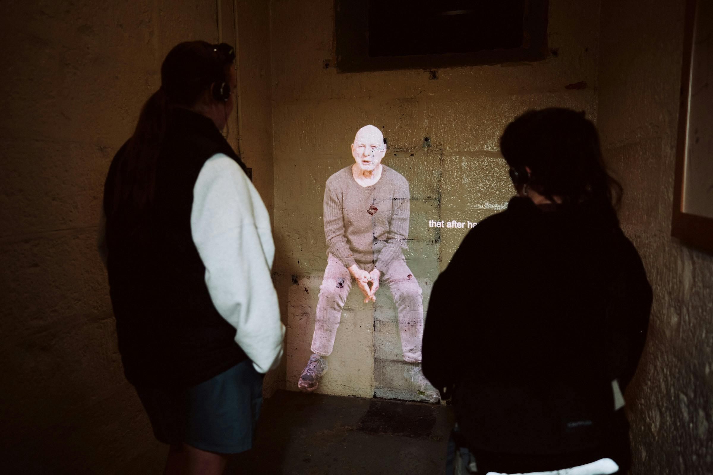 Two people inside cell watching video