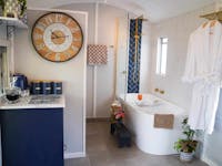 Stylish train carriage bath with gold fixtures, deep tub, and cozy decor for a relaxing escape.