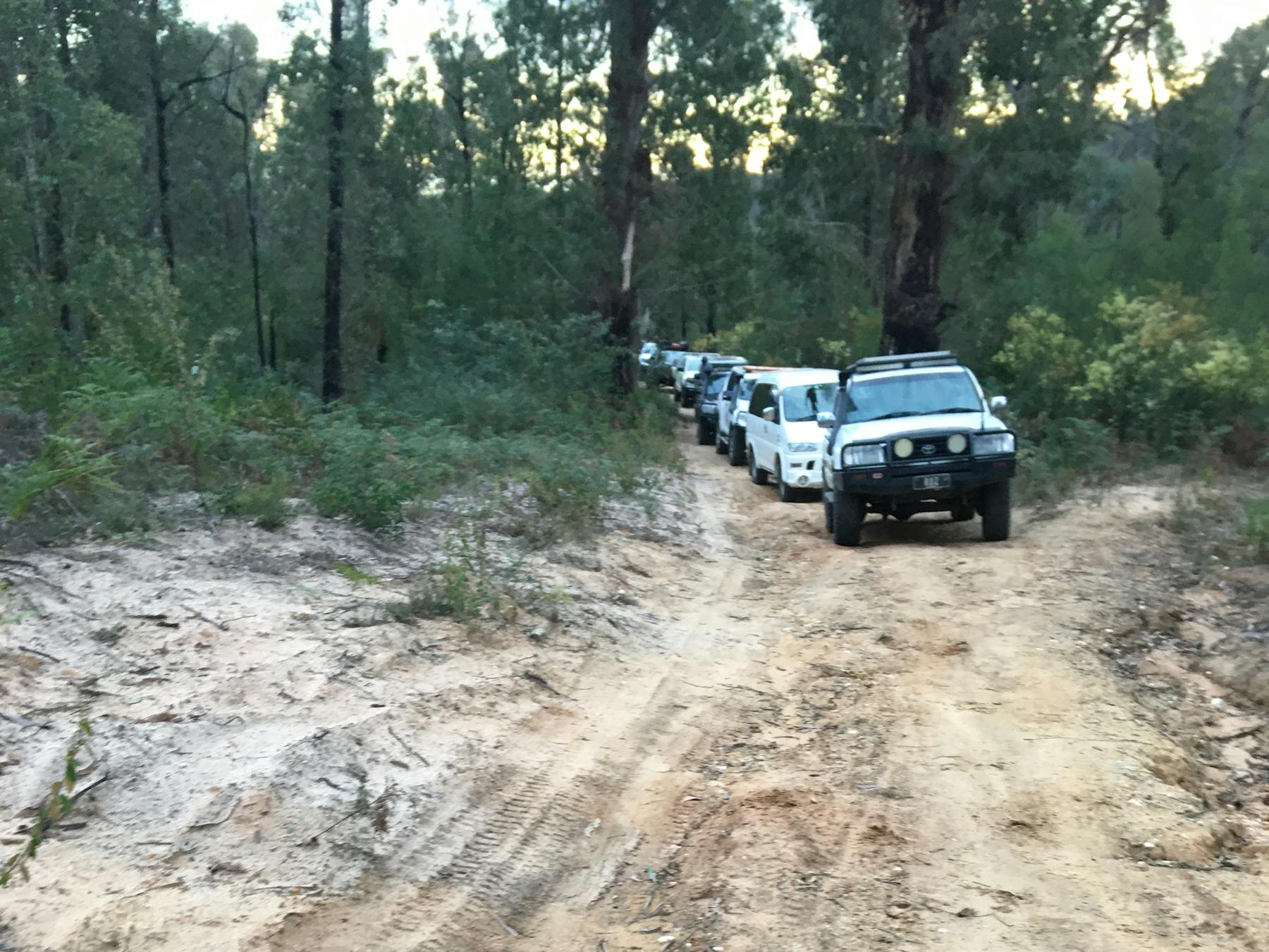 A Convoy of 4-Wheel Drives, following each other down a dirt road.