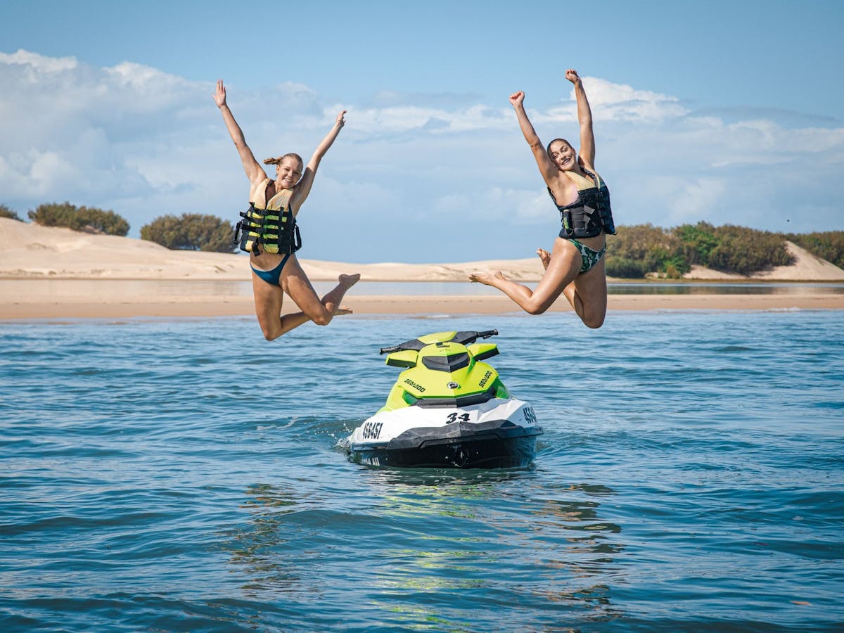 Two girls jumping off a jet ski Two girls jumping off a jet ski