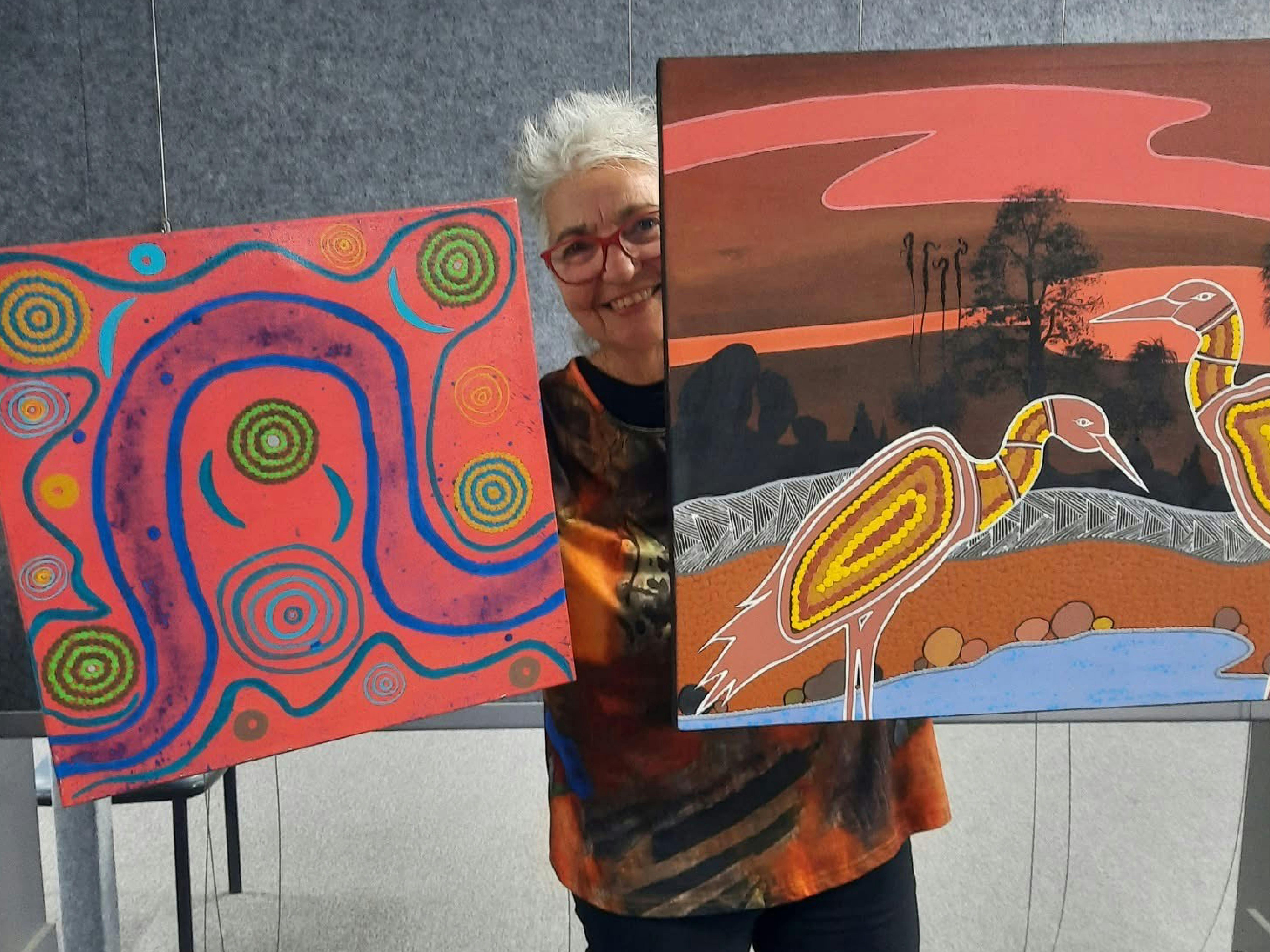 Art Director at Cassino Gallery holding Indigenous Artworks