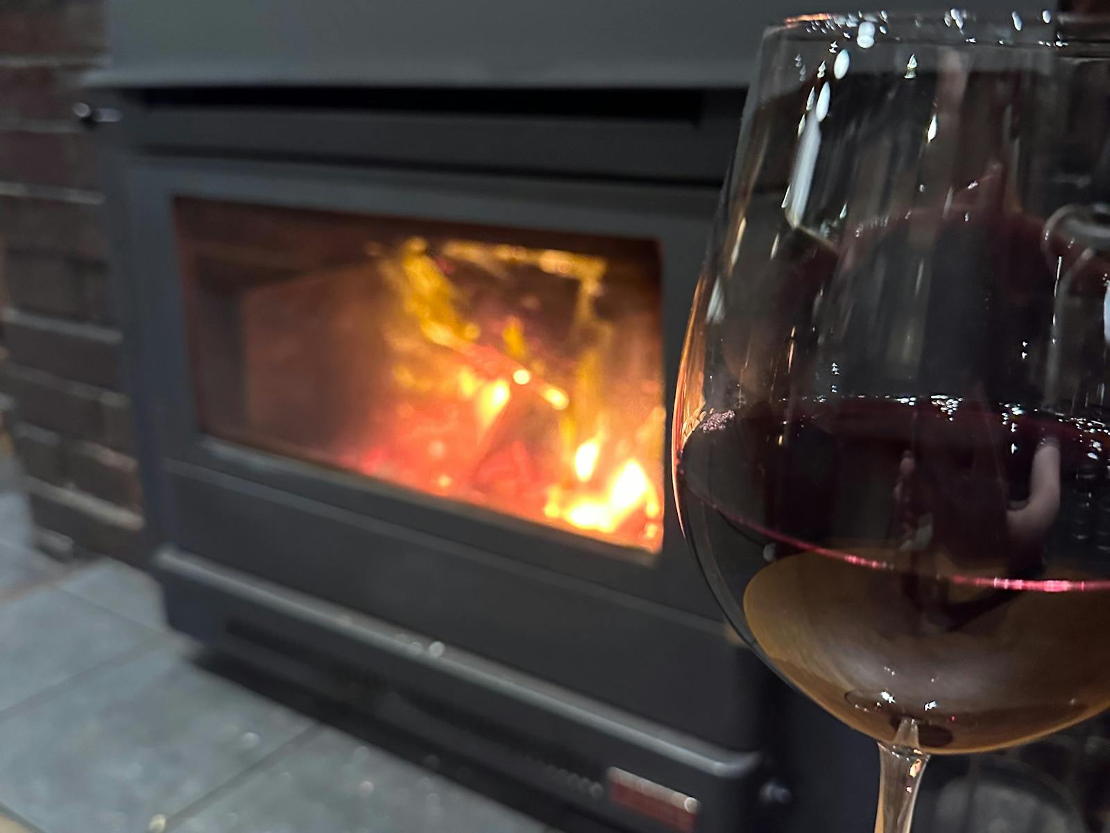 This photo is of our wood heater and a glass of local red wine