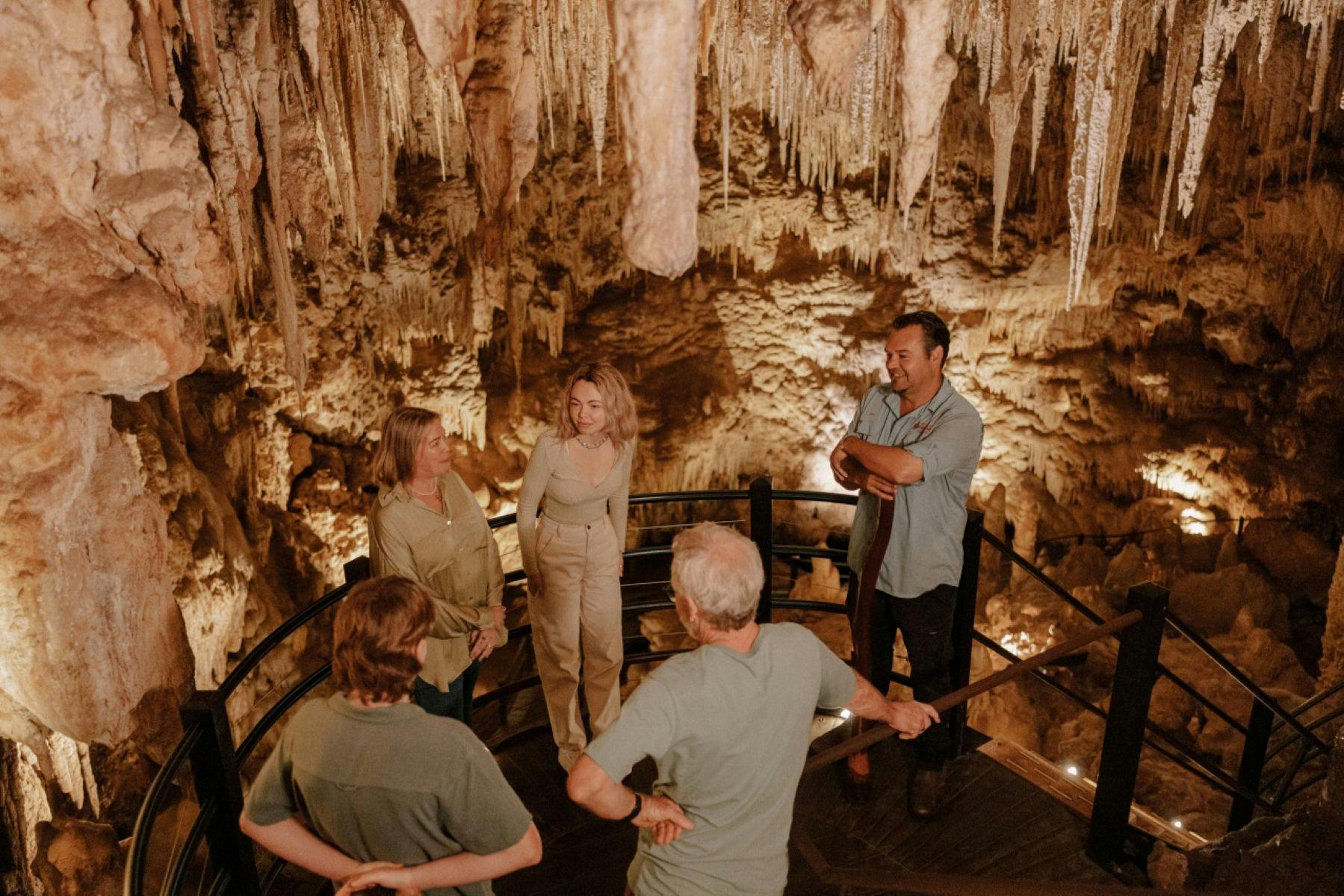 Visitors gathered around inside the cave while tour guide provides information
