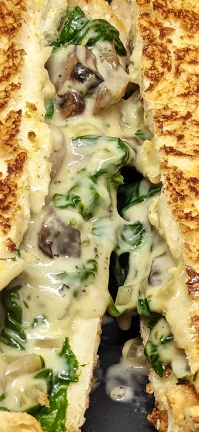Toasted sandwich cut in half with filling oozing out