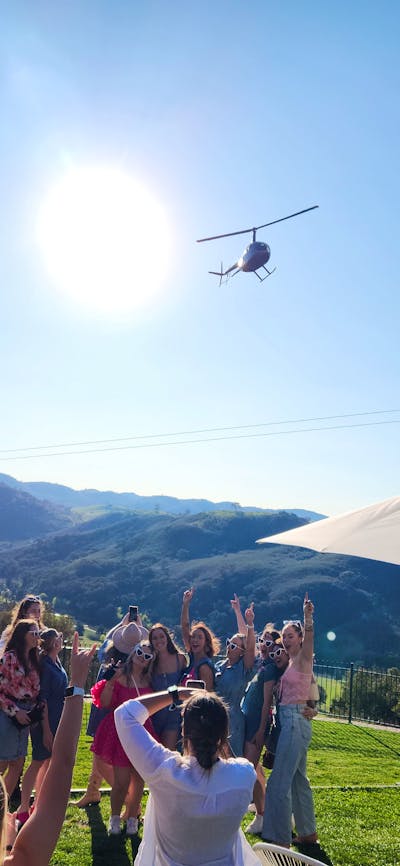 A cluster of individuals positioned in a field surrounded by nature