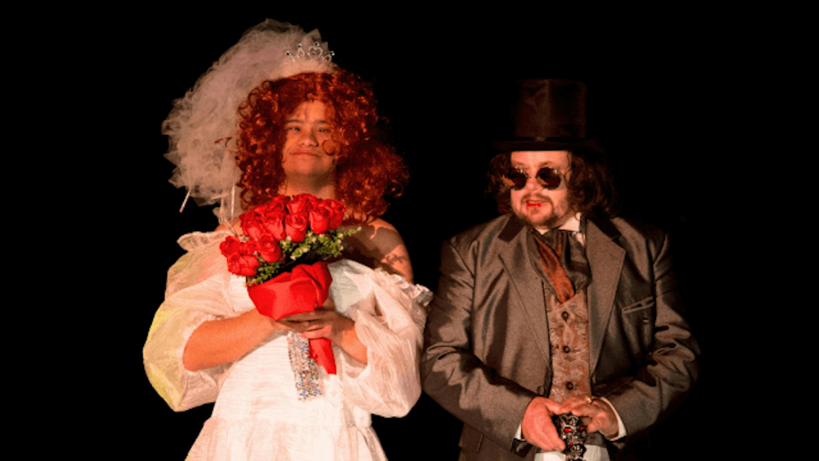 Two people standing side by side, in wedding attire.