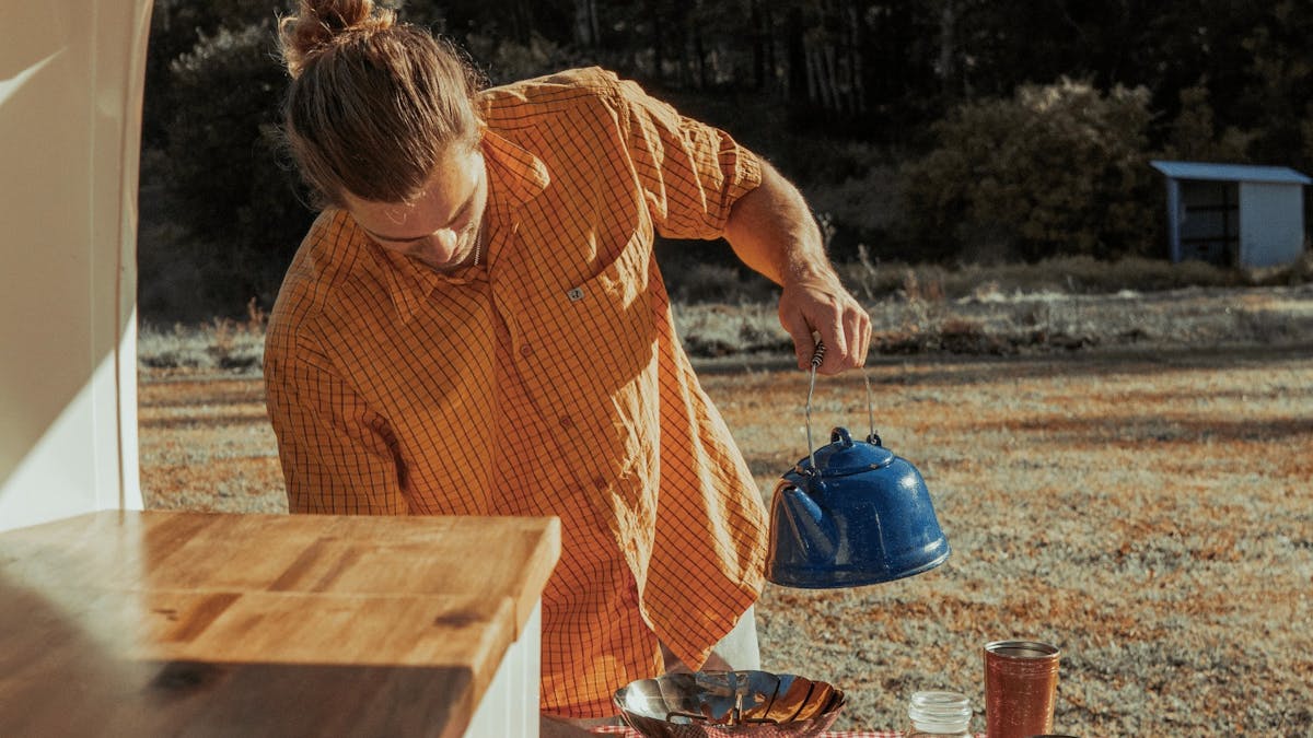 Young camper making coffeee