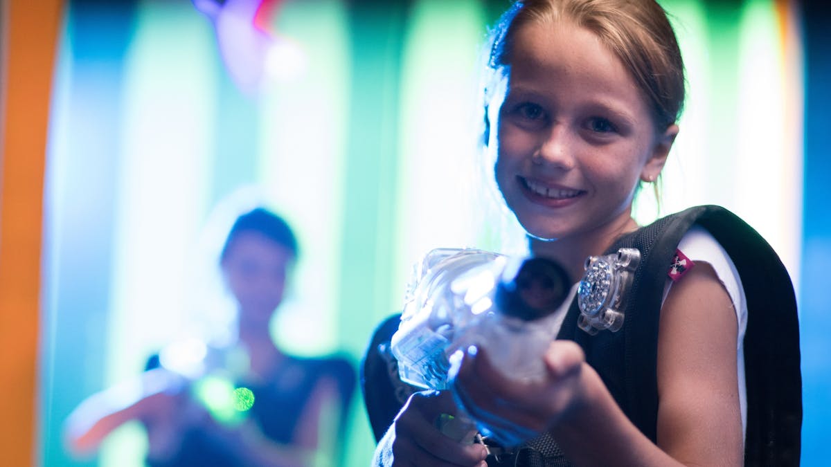 Young girls smiling at the camera while having fun playing Laser Tag at Laserzone Sunshine Coast
