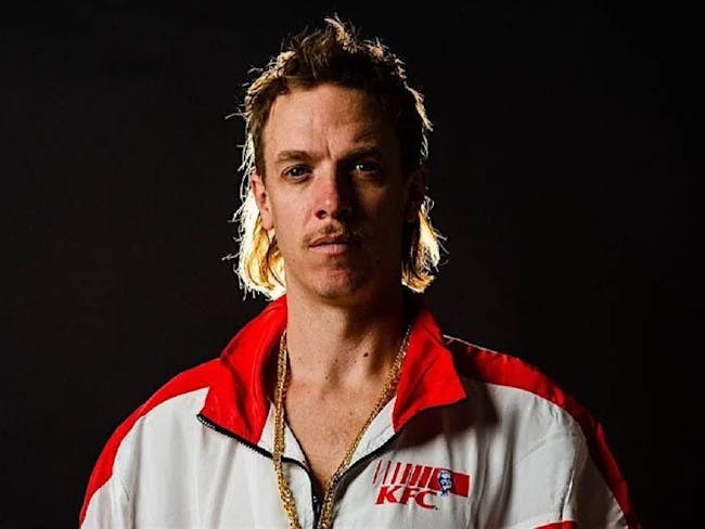 frenchy facing camera on a black background wearing a KFC branded jacket