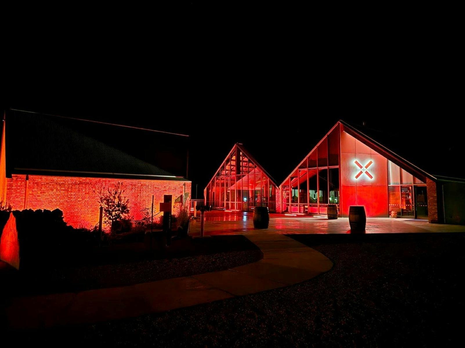 Callington Mill Distillery by night lit up with red lights