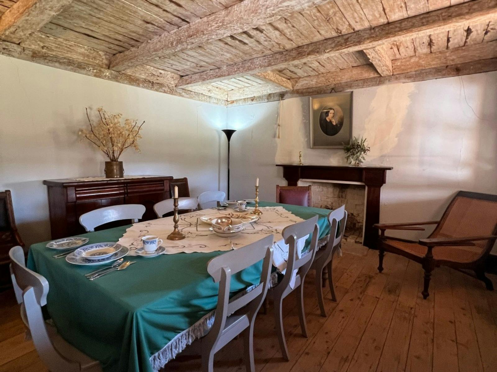 A light beams on an old larb and plaster roof. A dining table sits below.