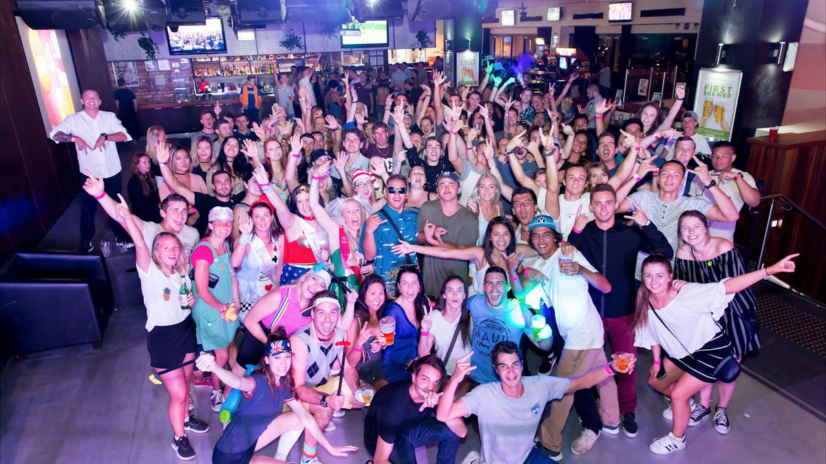 Whole group party tours posing for a photo, at the beginning of the club crawl