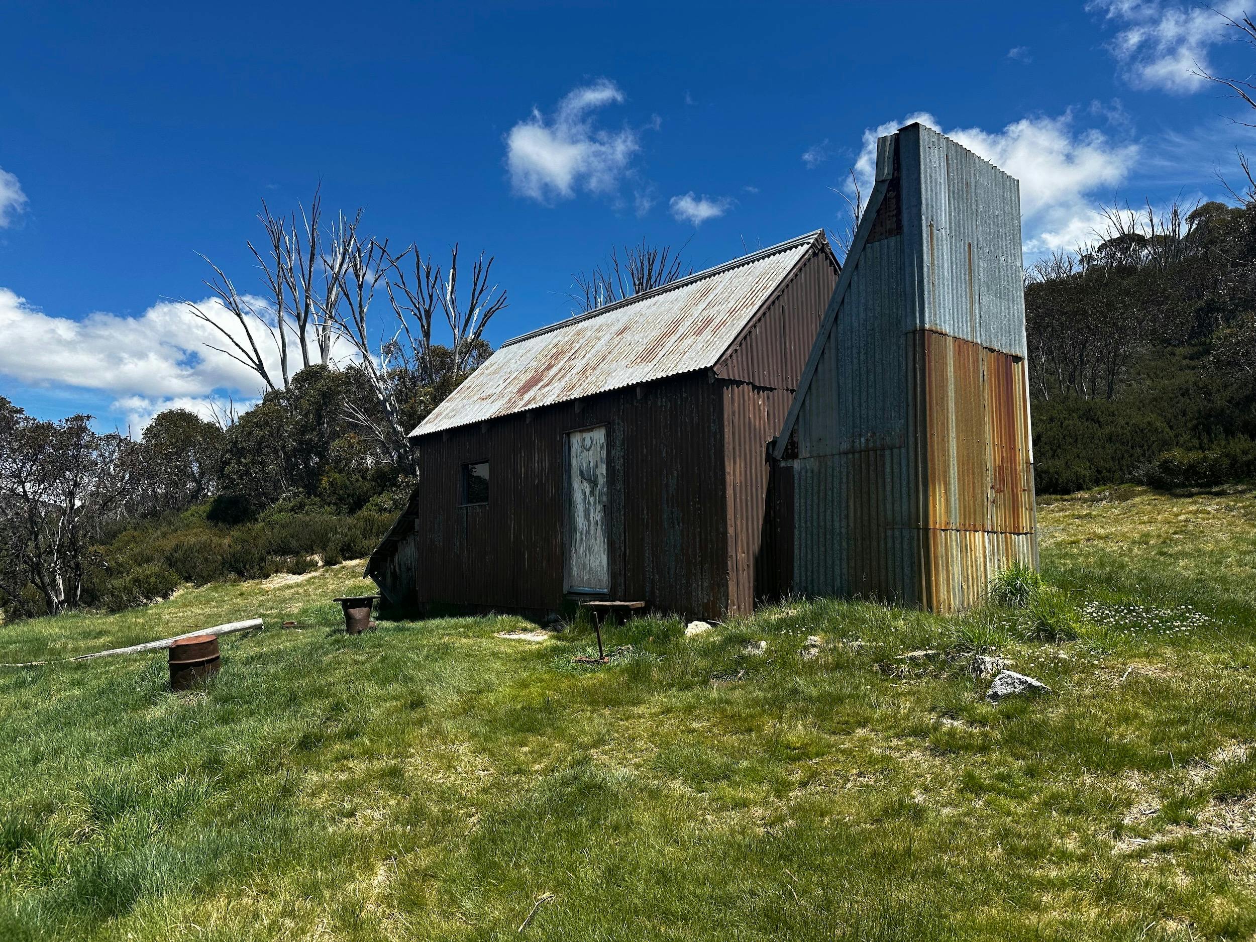An iron hut surrounded by green grass.