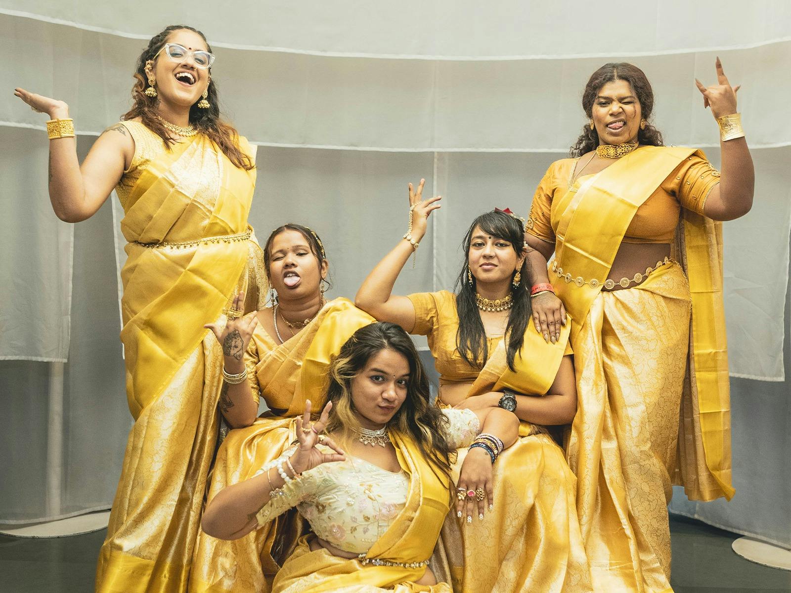 Wild Wild Women in yellow outfits making faces and hand gestures while looking at camera