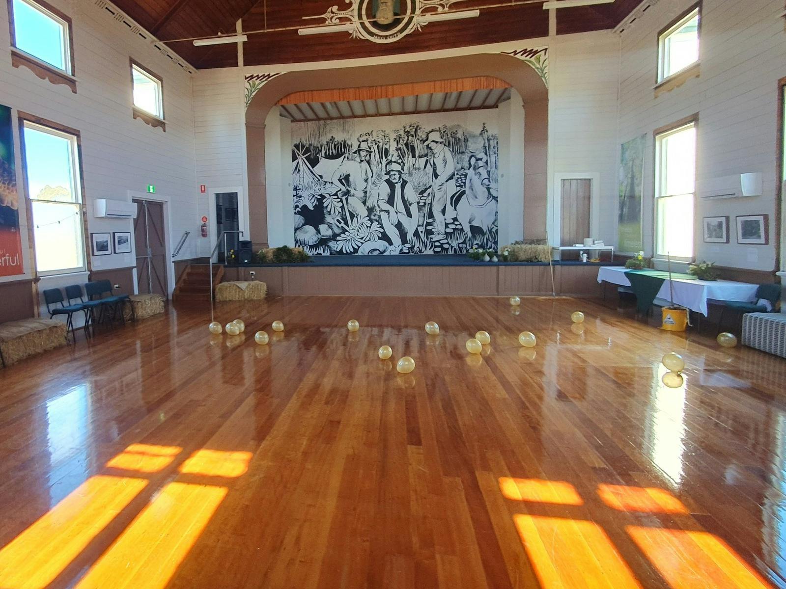 Interior of Athenaeum Hall in Waratah, showing the timber dance floor, stage and historic wooden cei