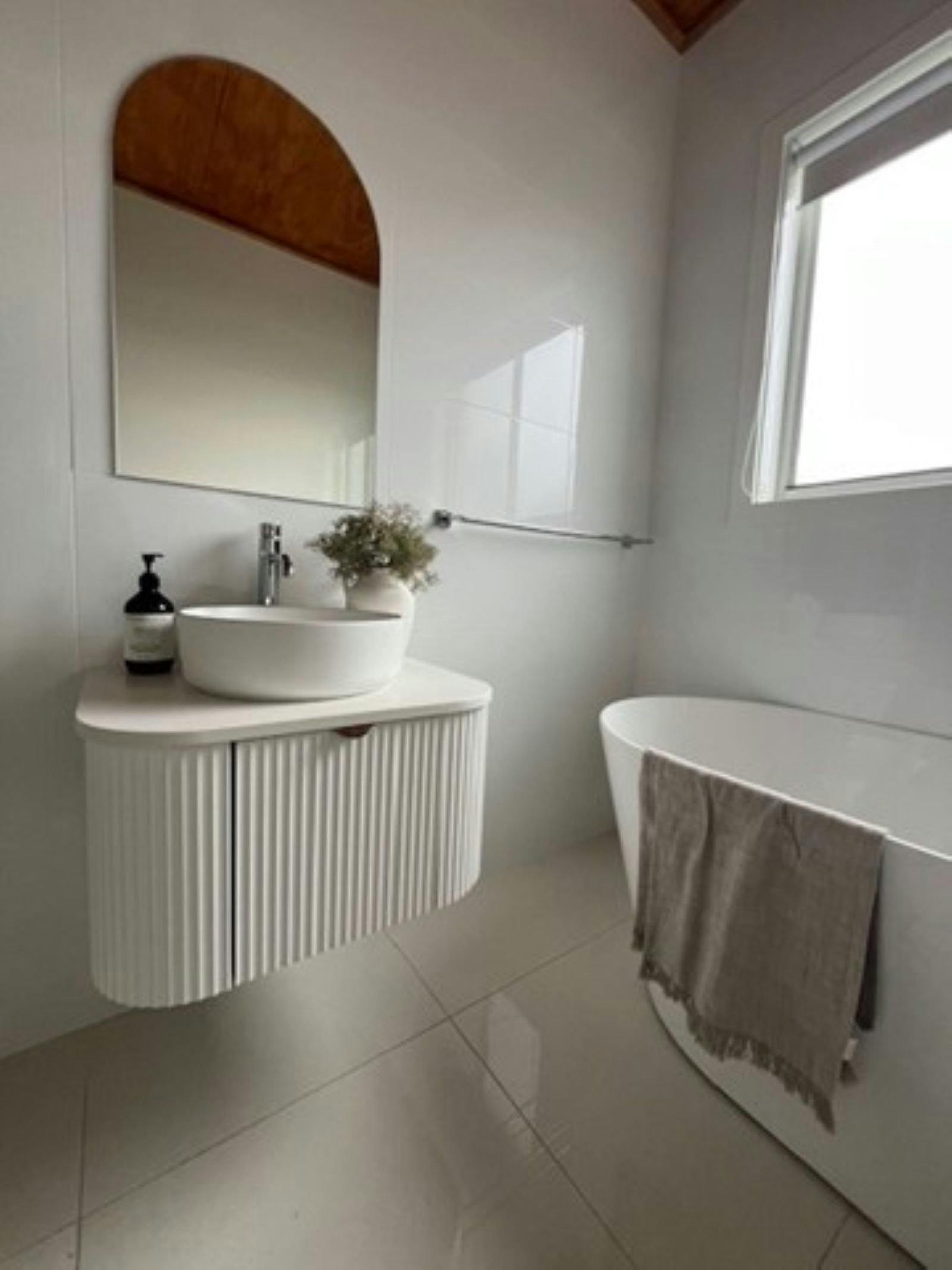 Free standing bathtub, suspended vanity unit all in neutral tones