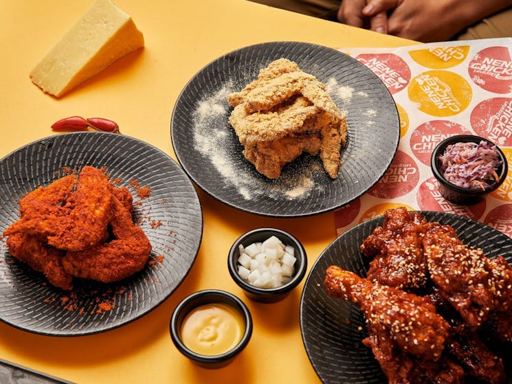 3 plates of korean fried chicken on a table