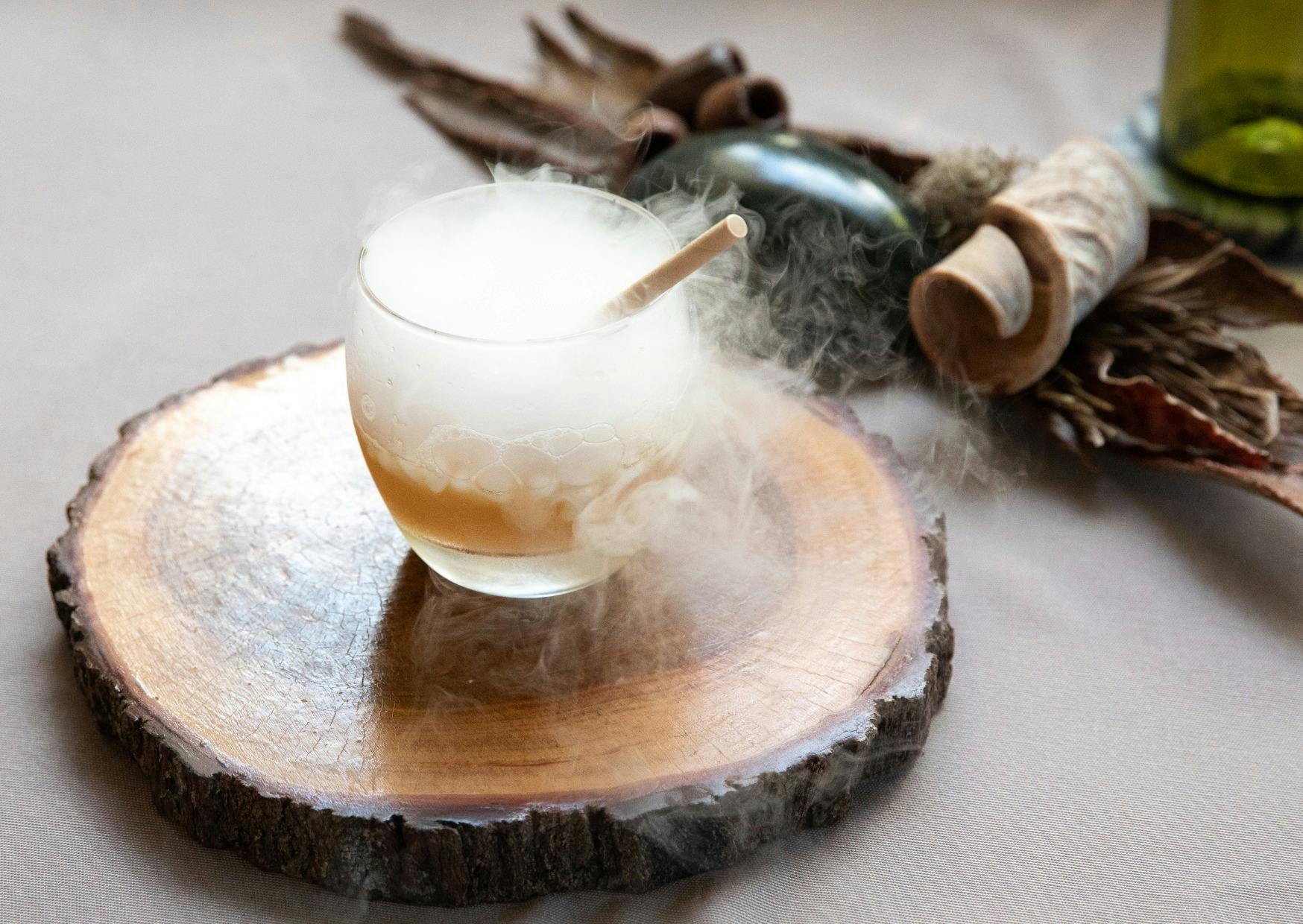 An aromatic cleansing beverage with a cool mist billowing from the vibrant liquid looks  enchanting