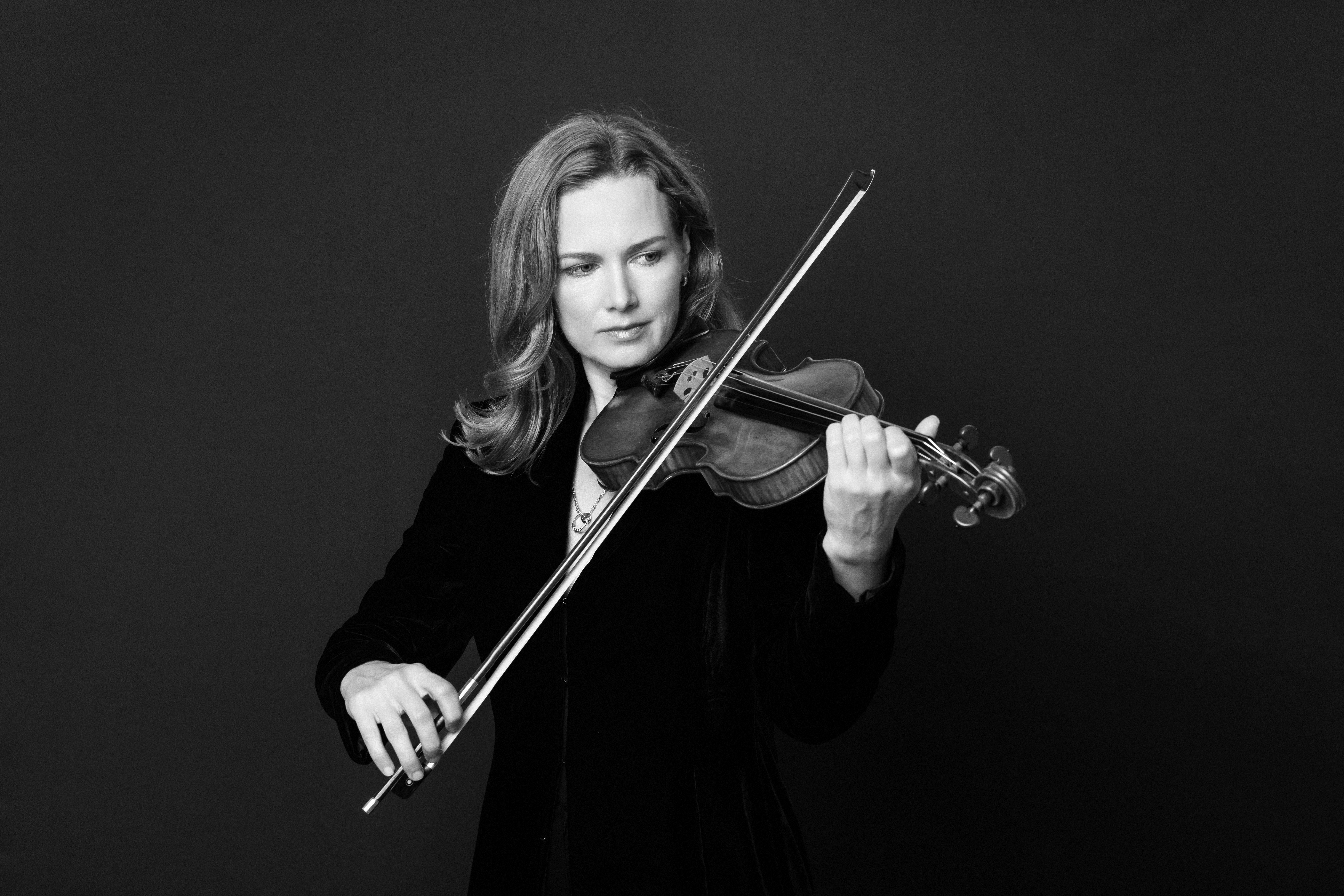Satu Vanska holding a violin and bow
