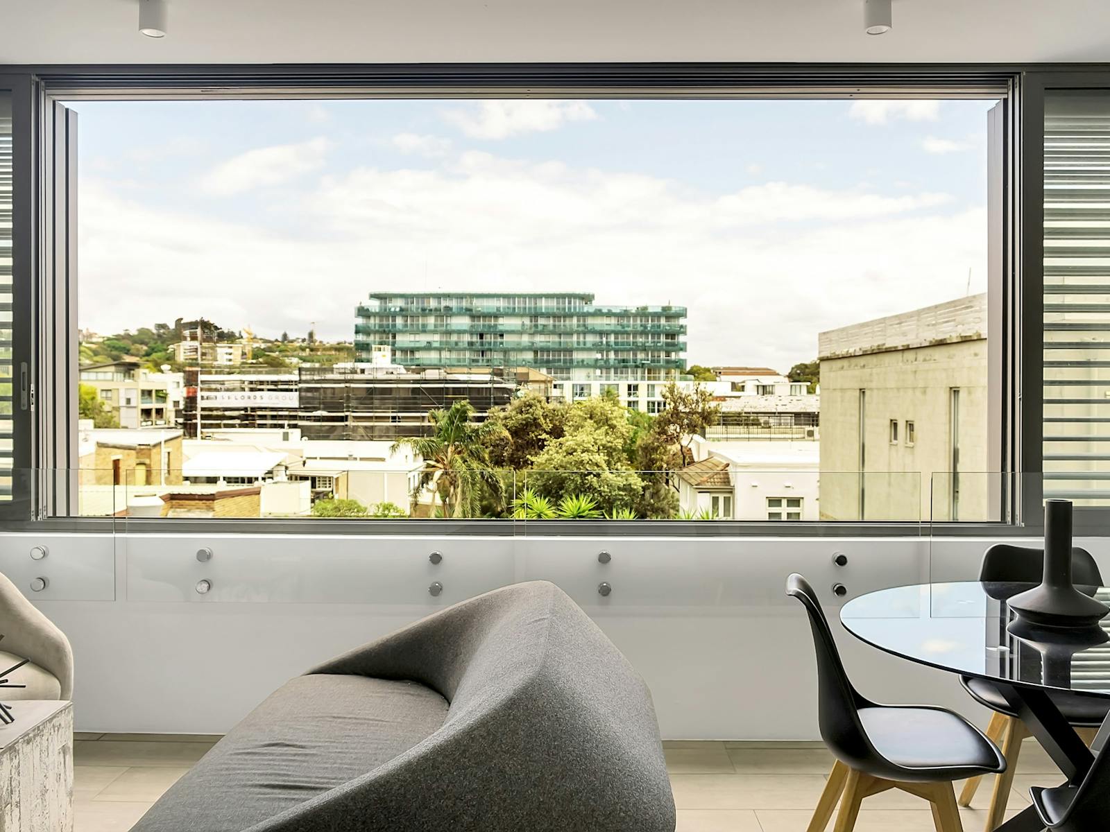 Dining area with stylish black chairs and a view of the city skyline.
