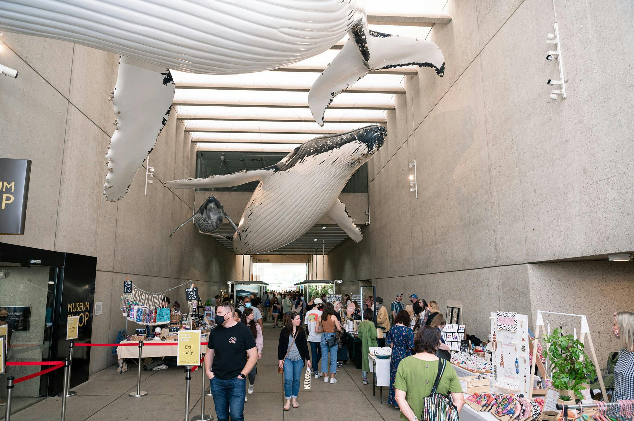 A views of customers shopping at the markets under the flying whale installation