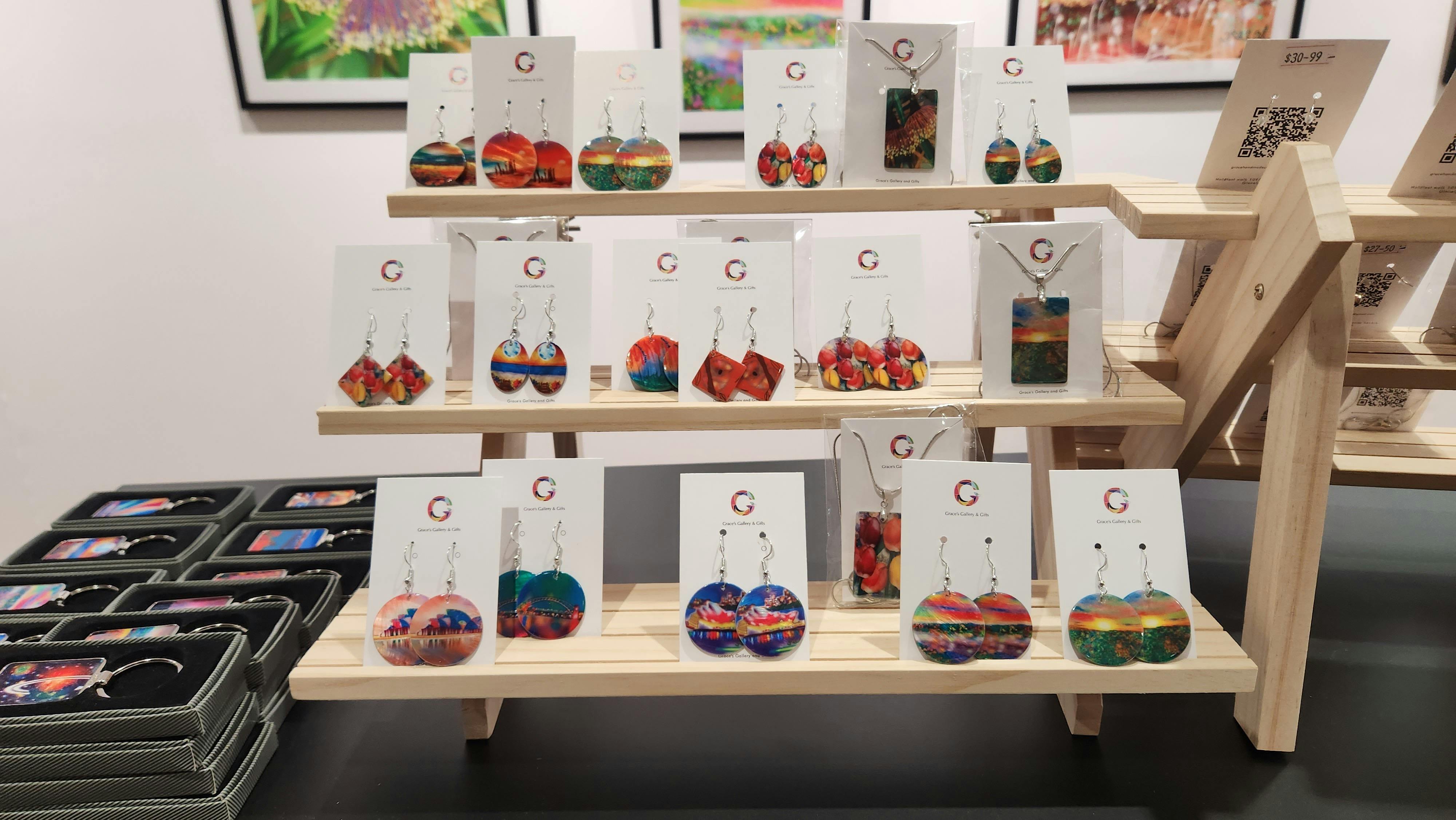 a display of multiple round , oval and diamond shaped earrings on a 3-tiered timber racks