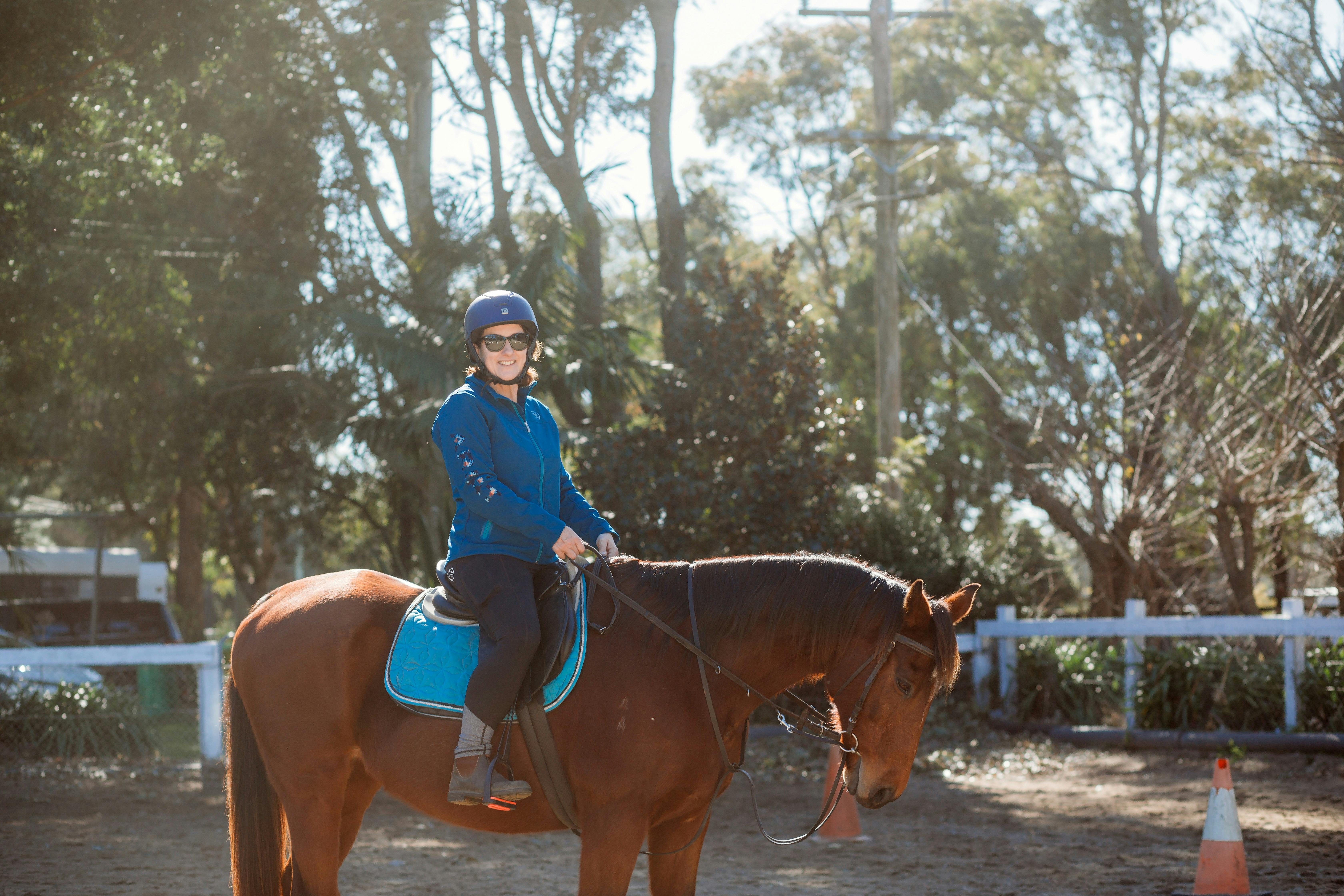 Lady riding a horse in arena