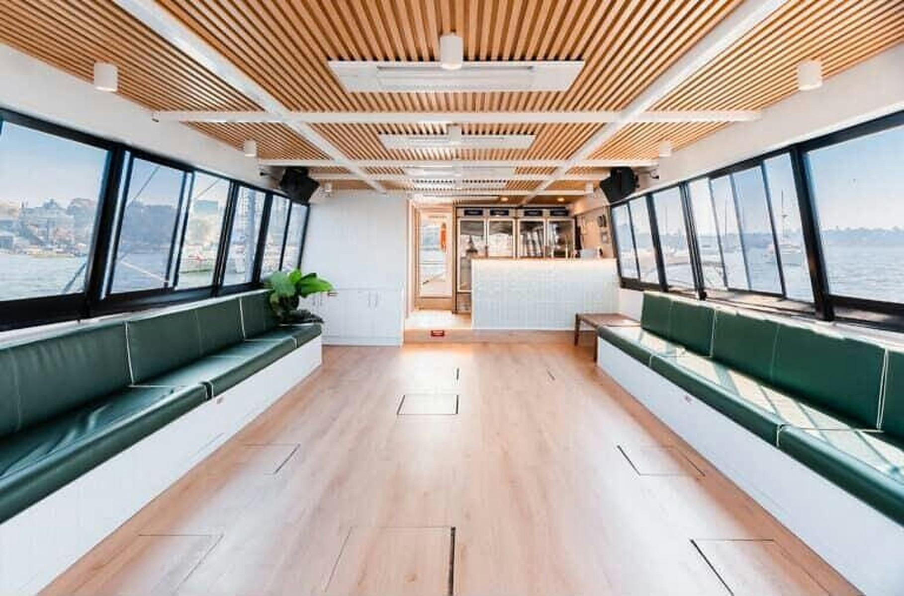 Interior of Zahara with green lounge seating along both sides, timber floors and a bar at the far en
