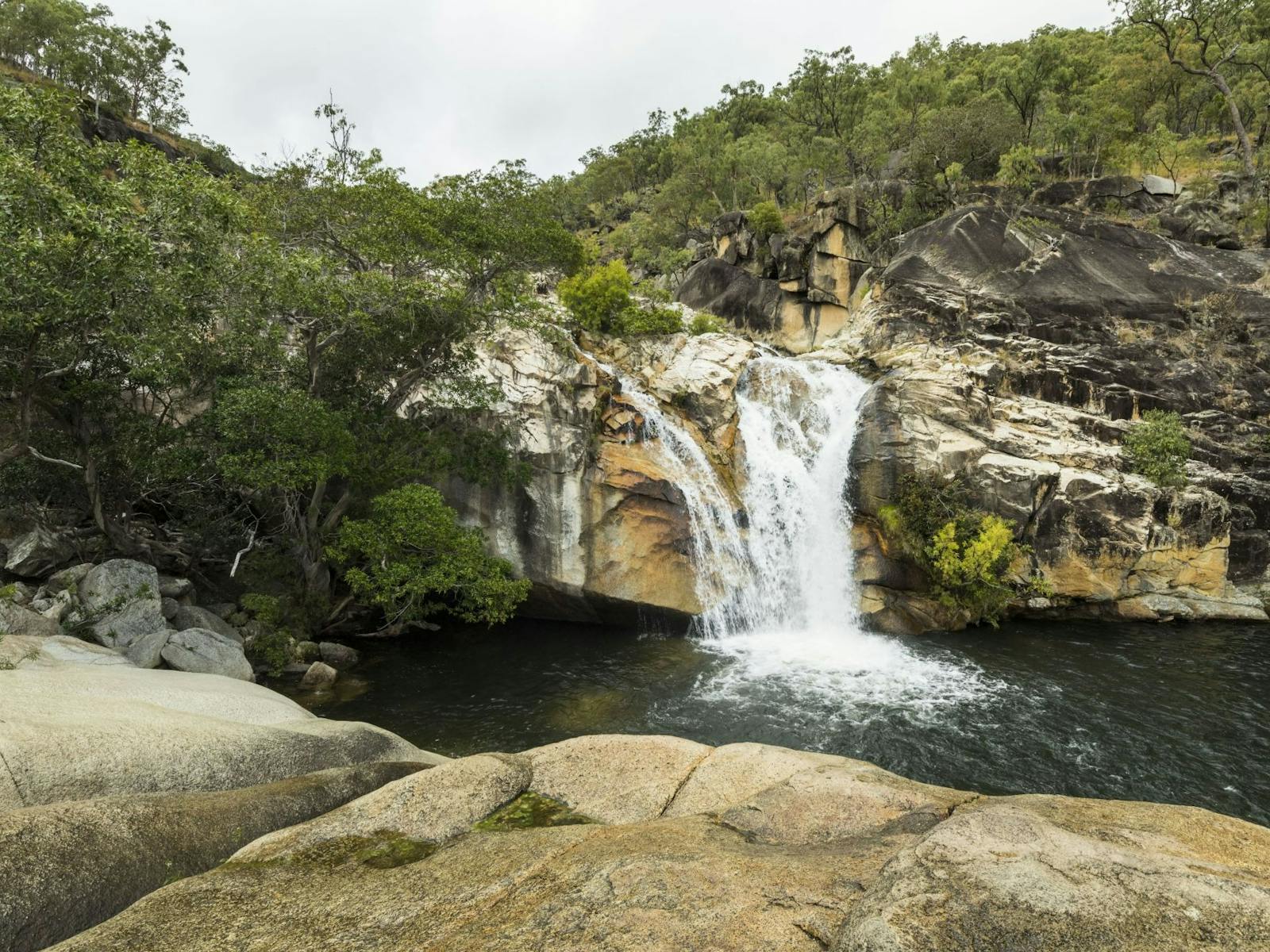Water cascading over granite boulders into a natural pool. Water cascading over granite boulders into a natural pool.