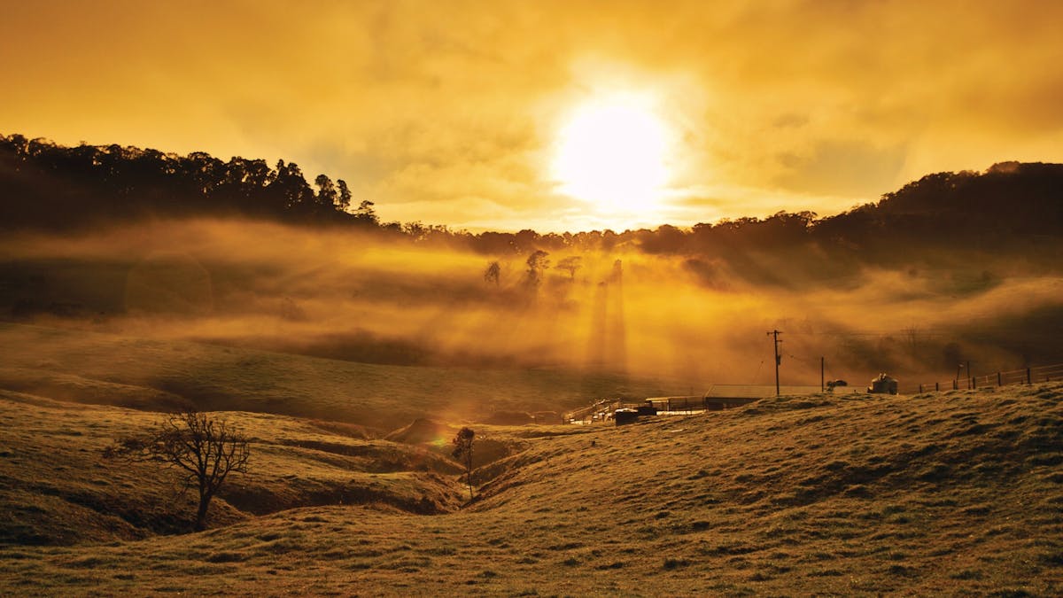 Sun setting over farm land