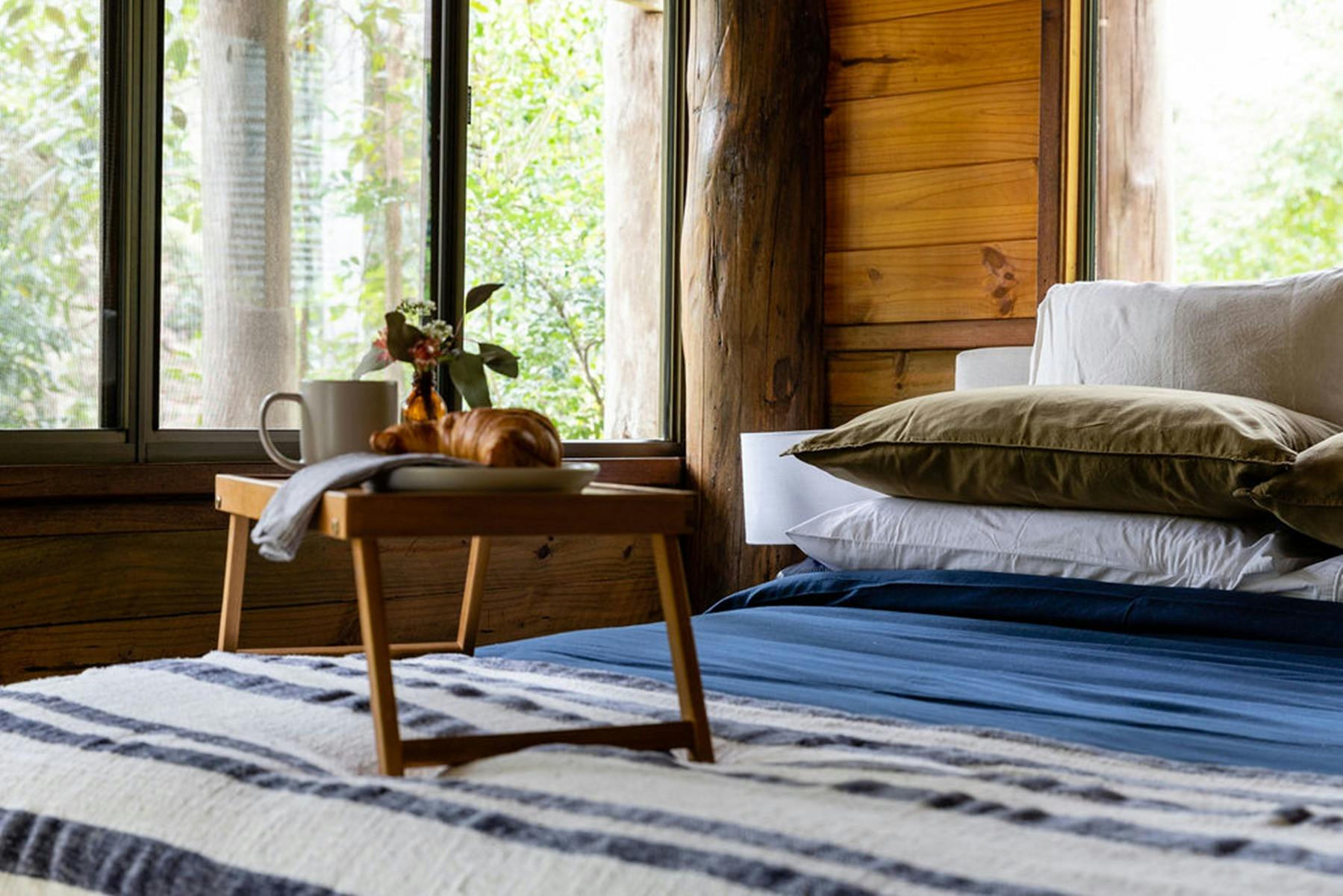 A bed with a breakfast tray on it in a Carawirry Cabin